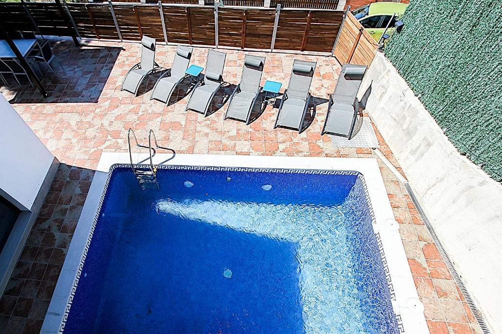 an overhead view of a swimming pool with chairs at Villa Esperanza in Vidreres