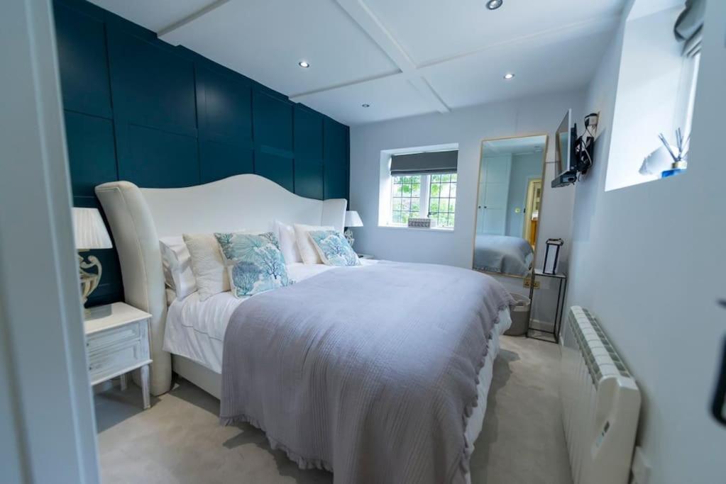 ein Schlafzimmer mit einem großen weißen Bett mit blauen Wänden in der Unterkunft Weaver's Cottage in Smarden