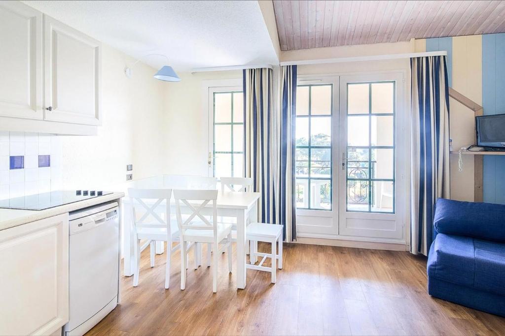 - une cuisine avec une table et des chaises blanches dans la chambre dans l'établissement Résidence Port Bourgenay - maeva Home - 2 Pièces 4 Personnes Sélection MAE-5309, à Talmont-Saint-Hilaire