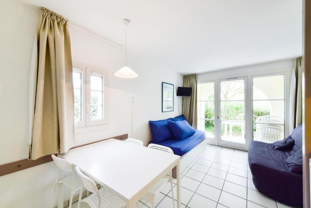 - un salon avec une table blanche et des oreillers bleus dans l'établissement Résidence Port du Crouesty - maeva Home - Studio 4 Personnes - Budget MAE-6829, à Arzon