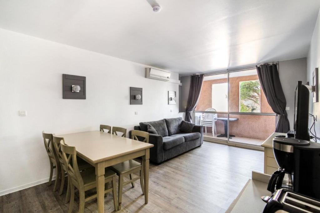 een woonkamer met een tafel en een bank bij Résidence Saint-Raphaël Valescure - maeva Home - Appartement 3 pièces 6 pe 80 in Valescure