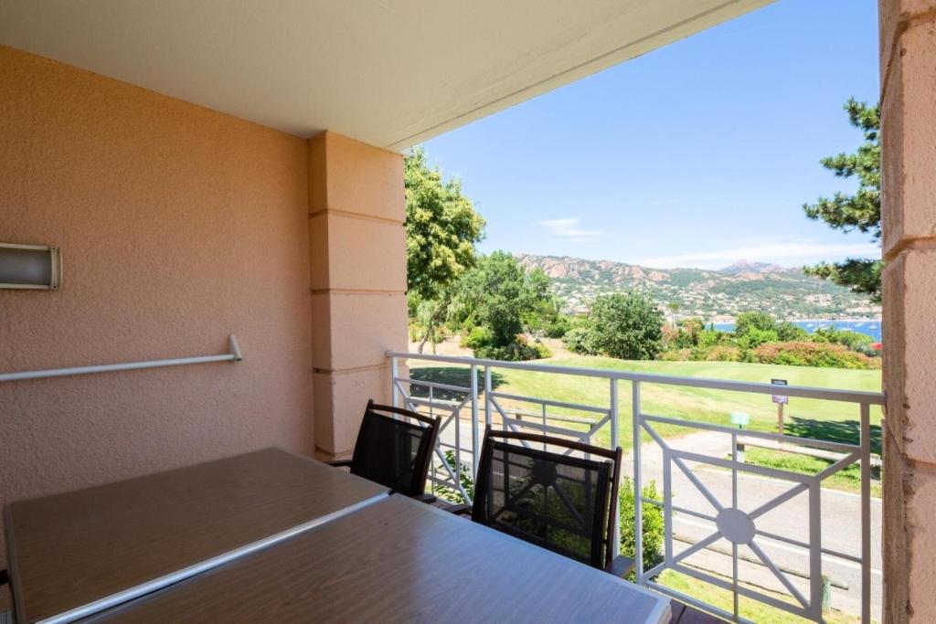Cette chambre dispose d'une table et d'un balcon avec vue. dans l'établissement Résidence le Village de Cap Esterel - maeva Home - Appartement 2 pieces 5 personnes Selection MAE-3658, à Saint-Raphaël