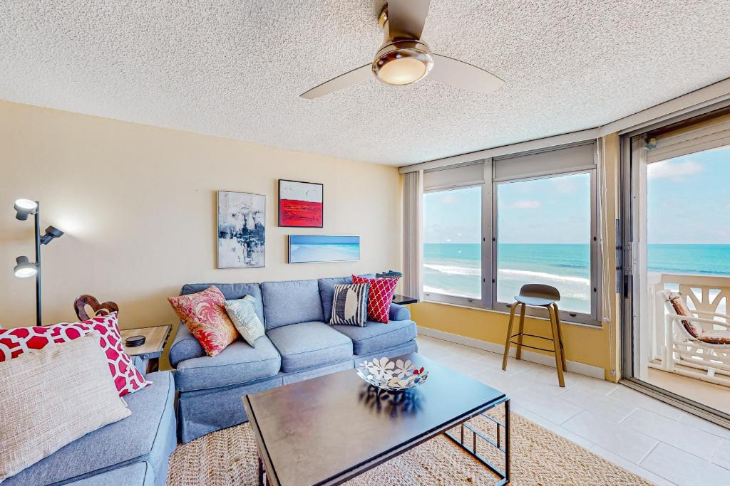 a living room with a blue couch and a table at The Sea Goose in Ormond Beach