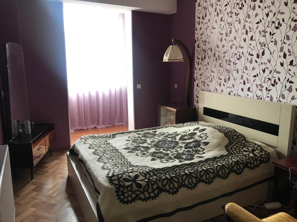 sypialnia z łóżkiem ze wzorzystą ścianą w obiekcie Apartament Luka w Bordżomi