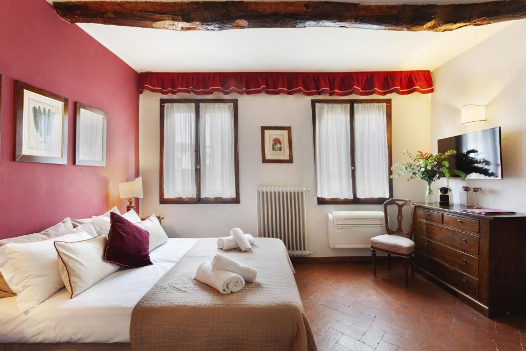 Un dormitorio con una cama grande y una pared roja. en S. Spirito Studio Flat, en Florencia