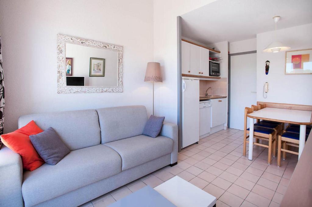 un salon avec un canapé et une cuisine dans l'établissement Résidence Port Bourgenay - maeva Home - Appartement duplex 2 Pièces 6 Personnes - Sélection MAE-2227, à Talmont-Saint-Hilaire