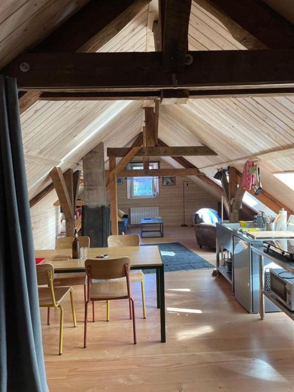 a room with a table and chairs in a attic at Mon refuge en Vasgovie in Meisenthal
