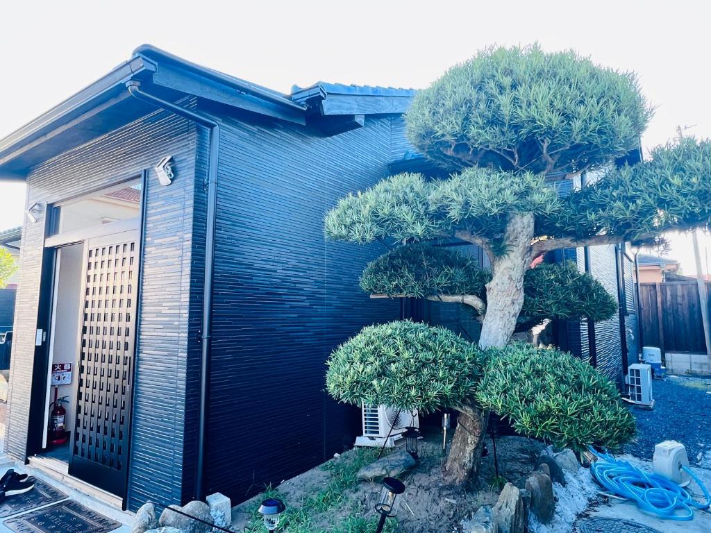 a blue house with a tree in front of it at Jun Resort in Chiba