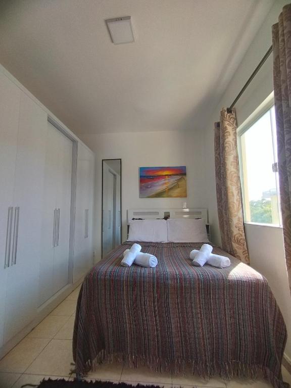 um quarto com uma cama com duas almofadas em Sweet Room Coroa Vermelha em Santa Cruz Cabrália