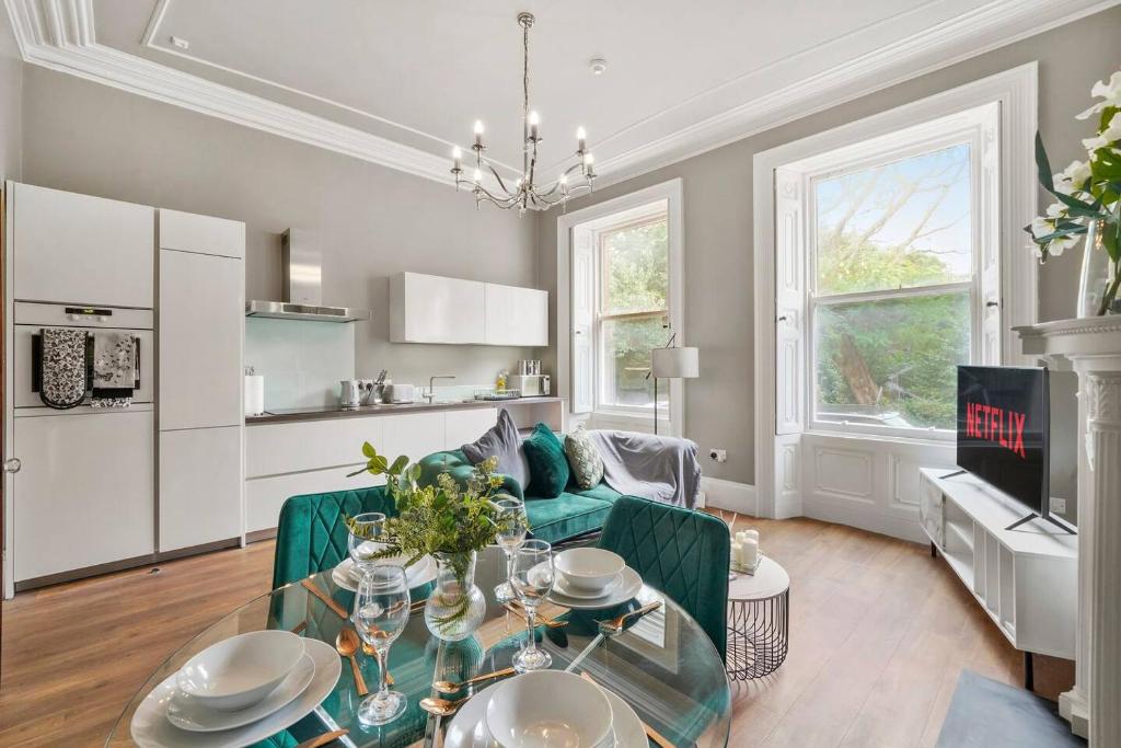 ein Wohnzimmer mit einem Tisch und einer Küche in der Unterkunft Stunning Central Wakefield Apartment 2 - Parking in Wakefield