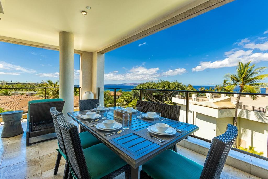 a table and chairs on a balcony with a view of the ocean at Wailea Beach Villas M312 condo in Wailea