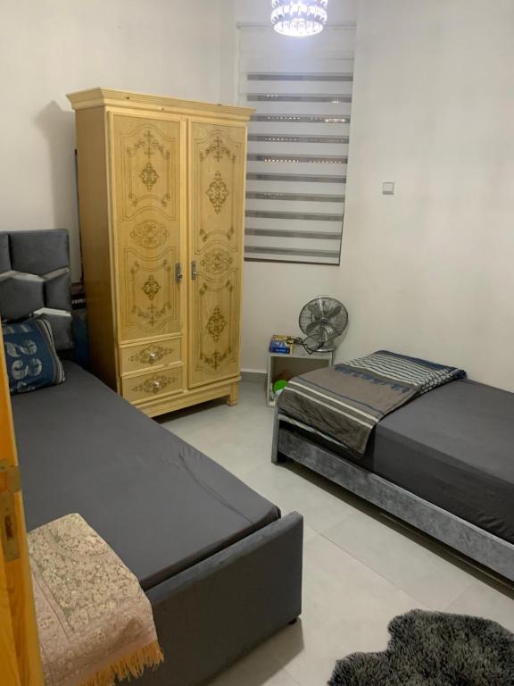 1 Schlafzimmer mit 2 Betten und einer Kommode in der Unterkunft Appartement Irena neuf à 5 min de la plage in Saidia 
