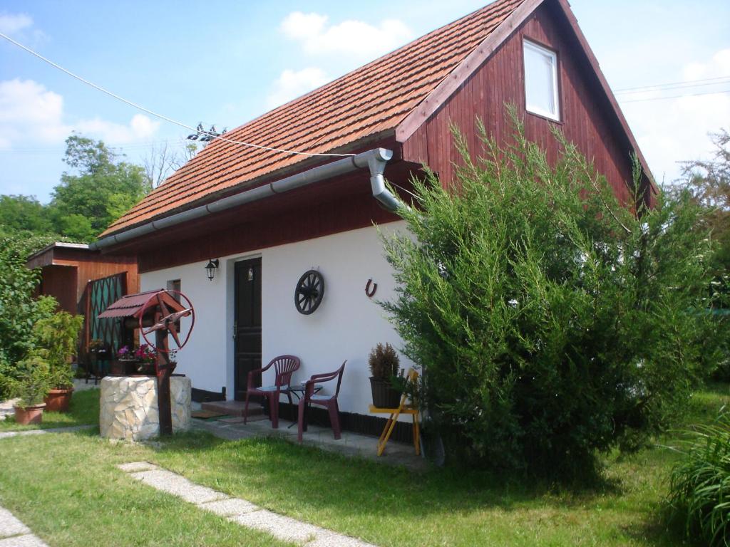 een rood-wit huis met een tafel en stoelen bij Podhajska ubytovanie - D&B Konecna in Trávnica