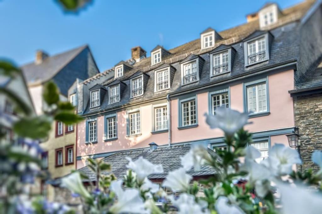 un bâtiment avec des fleurs blanches devant lui dans l'établissement Stadthaus Monschau Garden&Green (8 Gäste), à Monschau