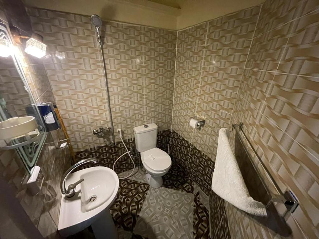 Łazienka z białą toaletą i umywalką w obiekcie Hotel New One w Kairze