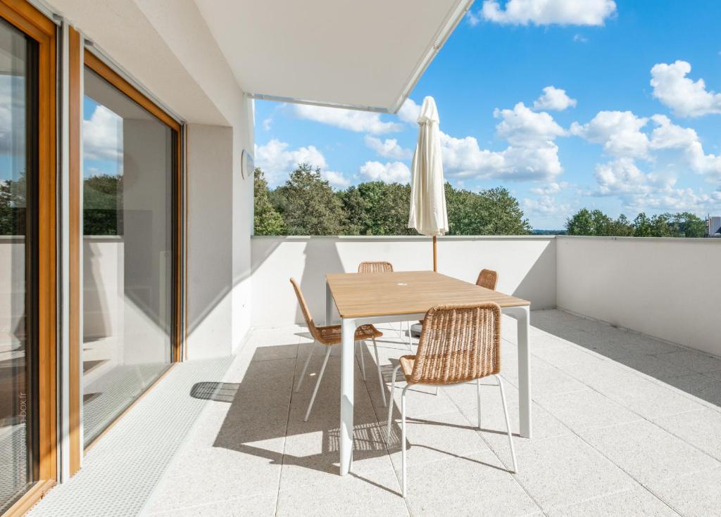 une salle à manger avec une table et des chaises sur un balcon dans l'établissement Chez André By Plaza - Proche Disneyland Paris, à Magny-le-Hongre