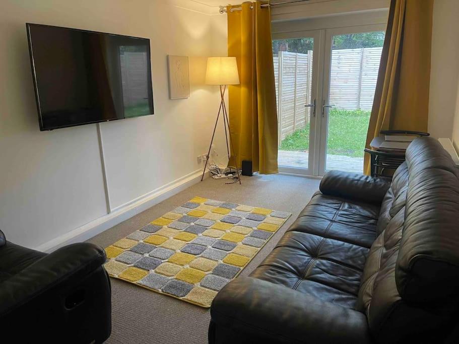 a living room with a couch and a flat screen tv at Cosy flat close to city centre. in Nether Edge