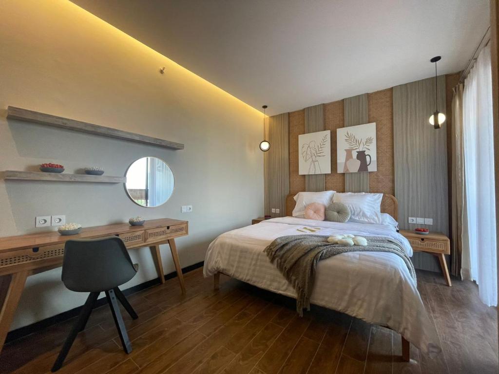 a bedroom with a bed with a desk and a desk at Stay.vie Hotel in Surabaya