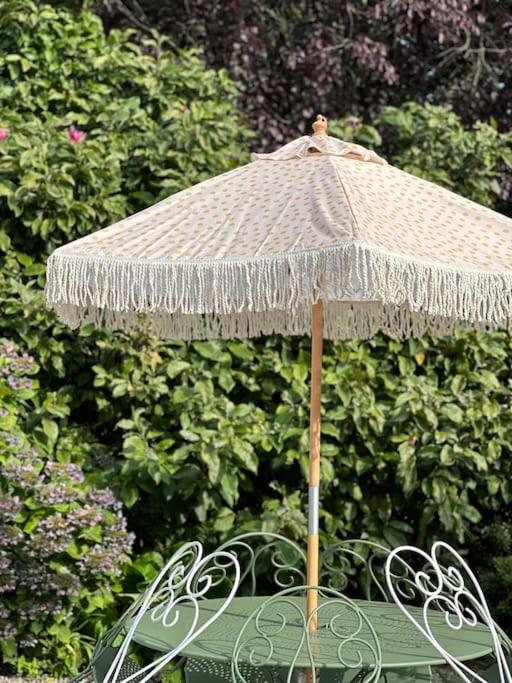 a straw umbrella sitting on top of a chair at Le Perchoir Gîte de charme dans château in Brix