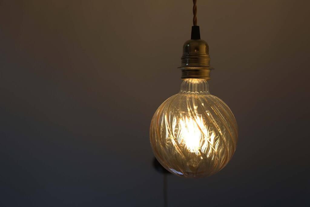 a glass light bulb hanging from a ceiling at Le Perchoir Gîte de charme dans château in Brix