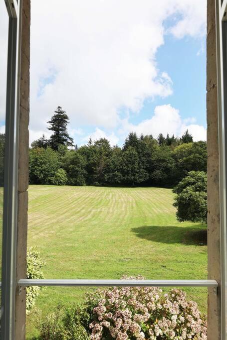 a view of a field of grass from a window at Le Perchoir Gîte de charme dans château in Brix