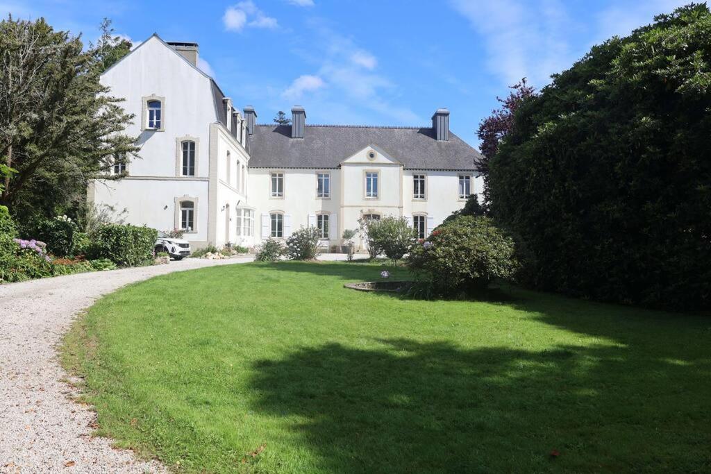 a large white house with a large yard at Le Perchoir Gîte de charme dans château in Brix