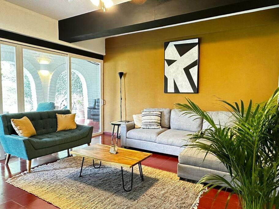 ein Wohnzimmer mit einem Sofa und einem Tisch in der Unterkunft Outstanding House in San Benito! in San Salvador