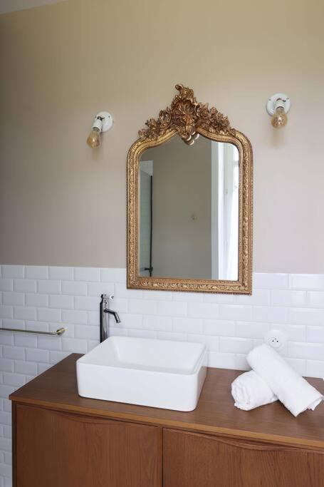 a bathroom with a white sink and a mirror at Le Perchoir Gîte de charme dans château in Brix