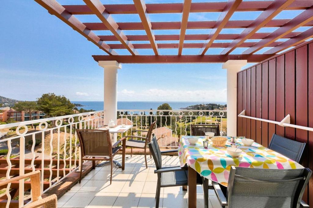 un patio avec une table et des chaises sur un balcon dans l'établissement Résidence le Village de Cap Esterel - maeva Home - Appartement 2 pièces 6 personnes - Sélection MAE-4826, à Saint-Raphaël
