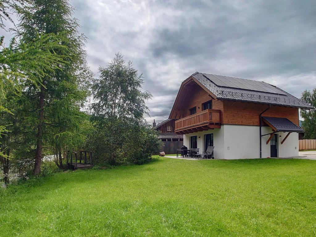 a house with a gambrel roof and a green yard at AlpiNest Feriendorf Lungau in Mariapfarr