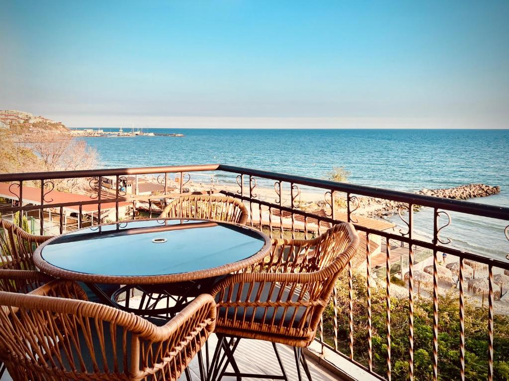 a table and chairs on a balcony overlooking the ocean at Beachfront Havana in Sveti Vlas