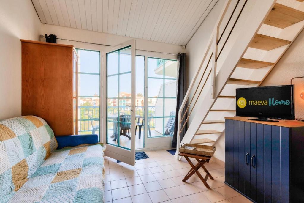 Cette chambre dispose d'un lit, d'une télévision et d'un escalier. dans l'établissement Résidence Port Bourgenay - maeva Home - Studio 6 personnes - Sélection MAE-4784, à Talmont-Saint-Hilaire