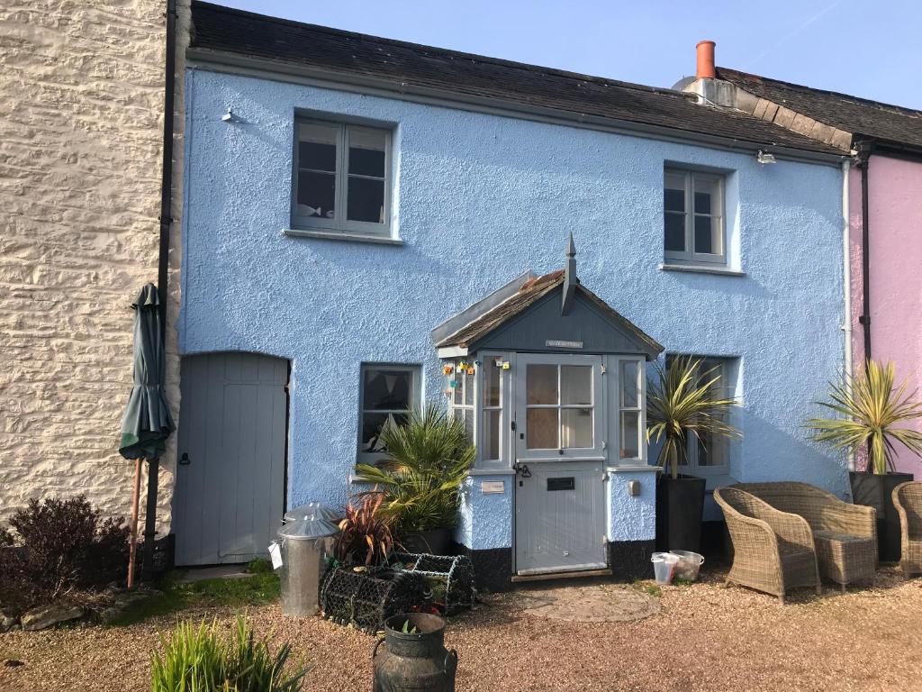 a blue house with a door and plants in front of it at Quay Cottage: Right on the Quay: Dittisham: Dartmouth: Devon at its best in Dittisham