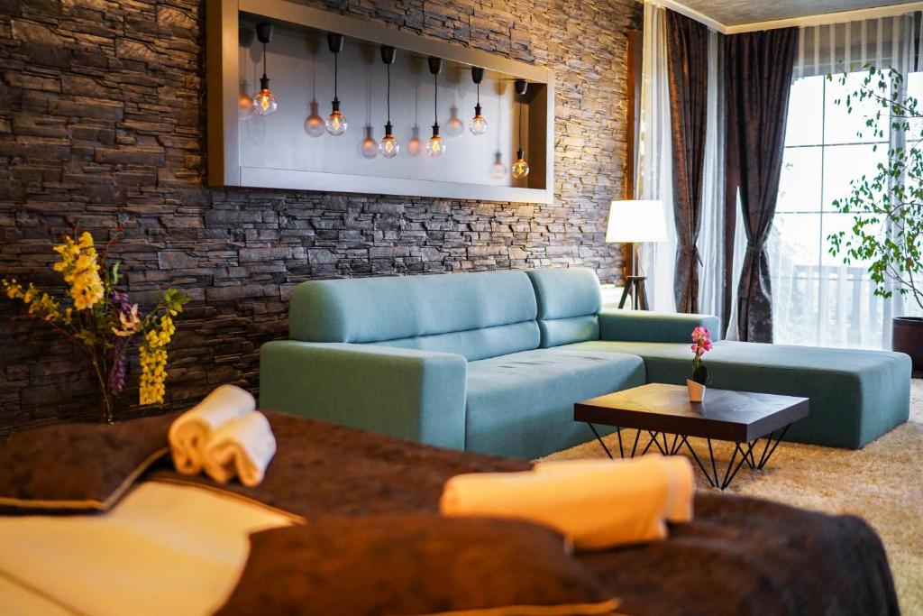 a living room with a blue couch and a brick wall at VIP House Glavatarski Han in Glavatartsi