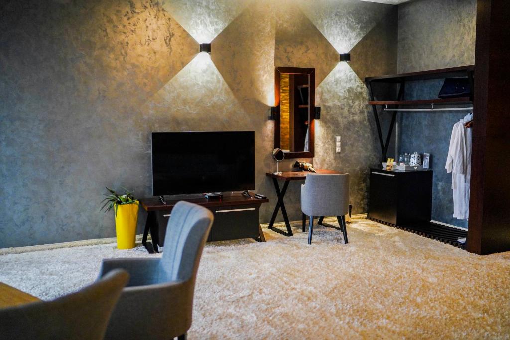 a living room with a television and a table and chairs at VIP House Glavatarski Han in Glavatartsi