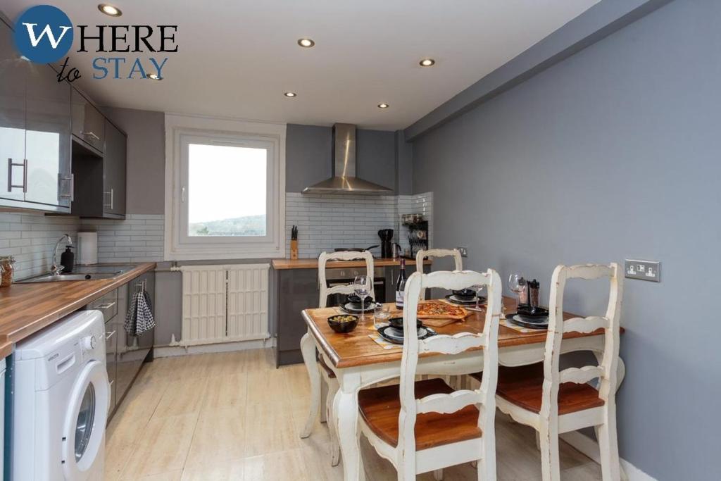 una cocina con mesa de madera y sillas. en Stylish 3 Bedroom Apartment, Edinburgh, en Edimburgo