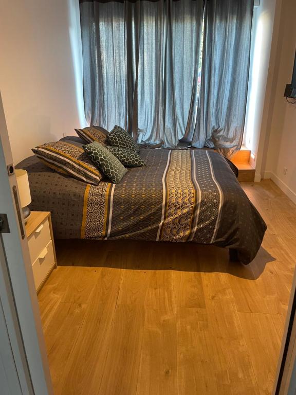 1 dormitorio con 1 cama con cortinas azules en Suite parentale avec salle de bains et toilettes privées, en Genas