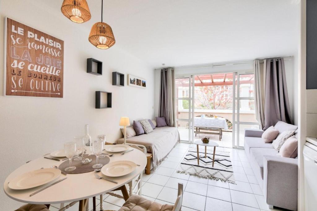 un salon avec une table et un canapé dans l'établissement Résidence le Village de Cap Esterel - maeva Home - Studio 4 personnes - Sélection MAE-8824, à Saint-Raphaël