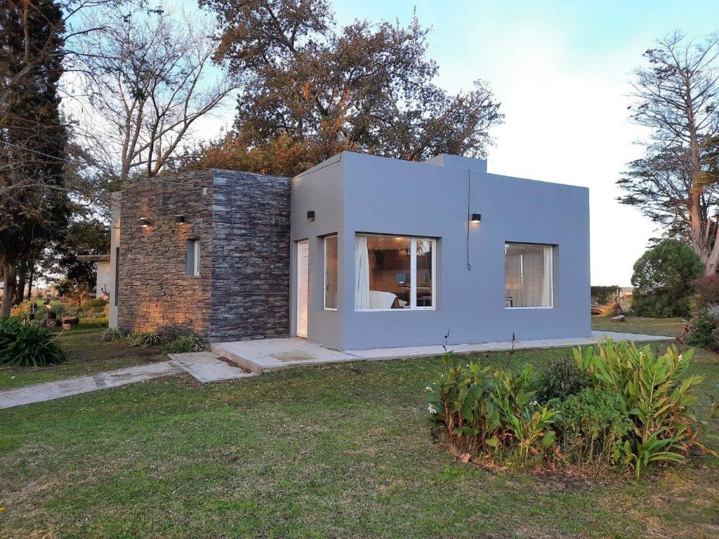 a small white house in a yard at Casa 3 ambientes in Balneario Mar Chiquita