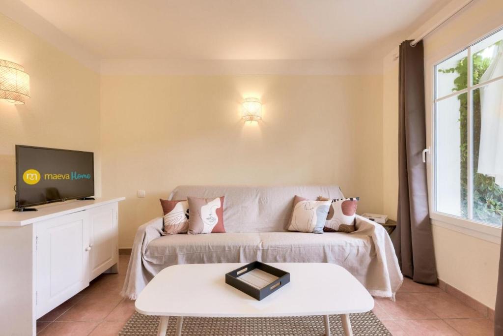 un salon avec un canapé et une télévision dans l'établissement Les Maisons de Lacanau les Pins - maeva Home - Maison 3 pièces 6 personnes - Prestige MAE-1624, à Lacanau
