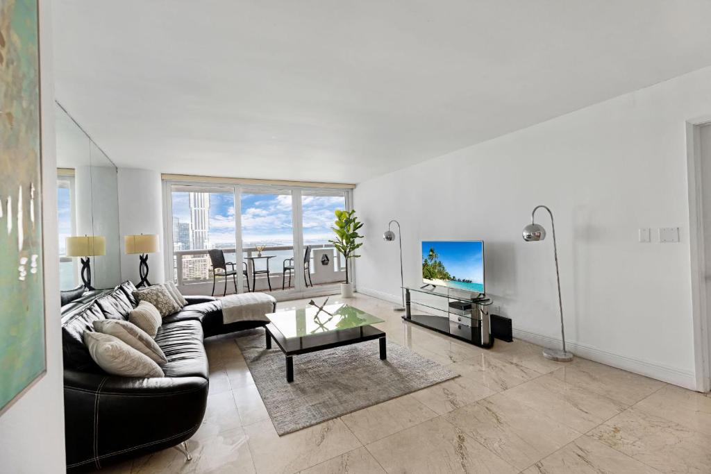 uma sala de estar com um sofá e uma mesa em Bayfront Gem with Balcony and Pool em Miami
