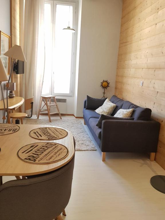 un salon avec un canapé bleu et une table dans l'établissement le petit chalet de Grenoble, à Grenoble