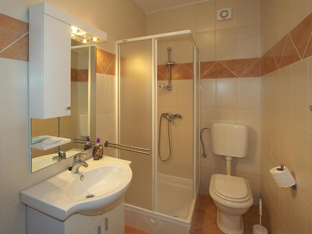 łazienka z prysznicem, umywalką i toaletą w obiekcie Apartments Novalja w Novalji