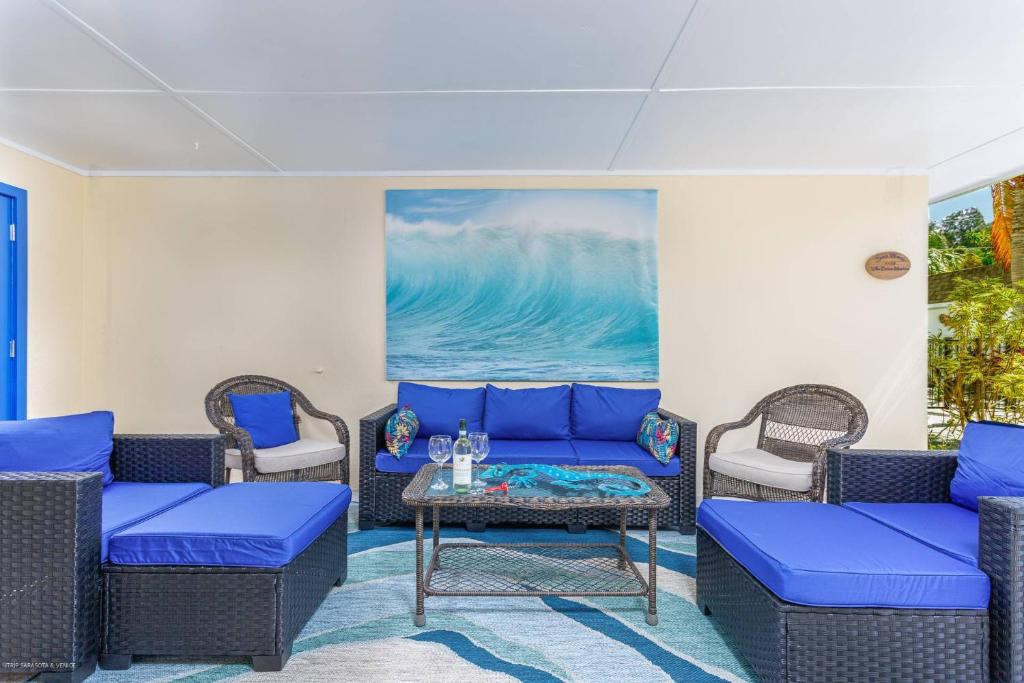 ein Wohnzimmer mit blauen Möbeln und einem Gemälde in der Unterkunft Lulu's Crescent Cottage #1 in Sarasota