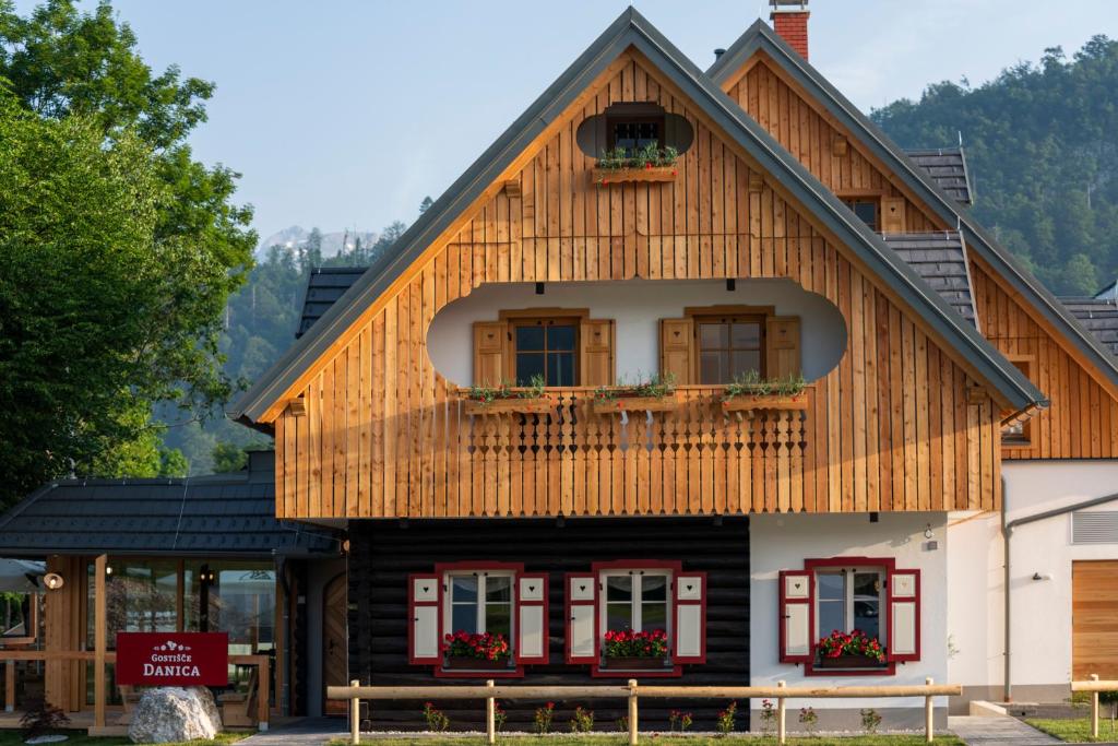 a wooden house with a gambrel roof at Guesthouse & Camping Danica Bohinj in Bohinj
