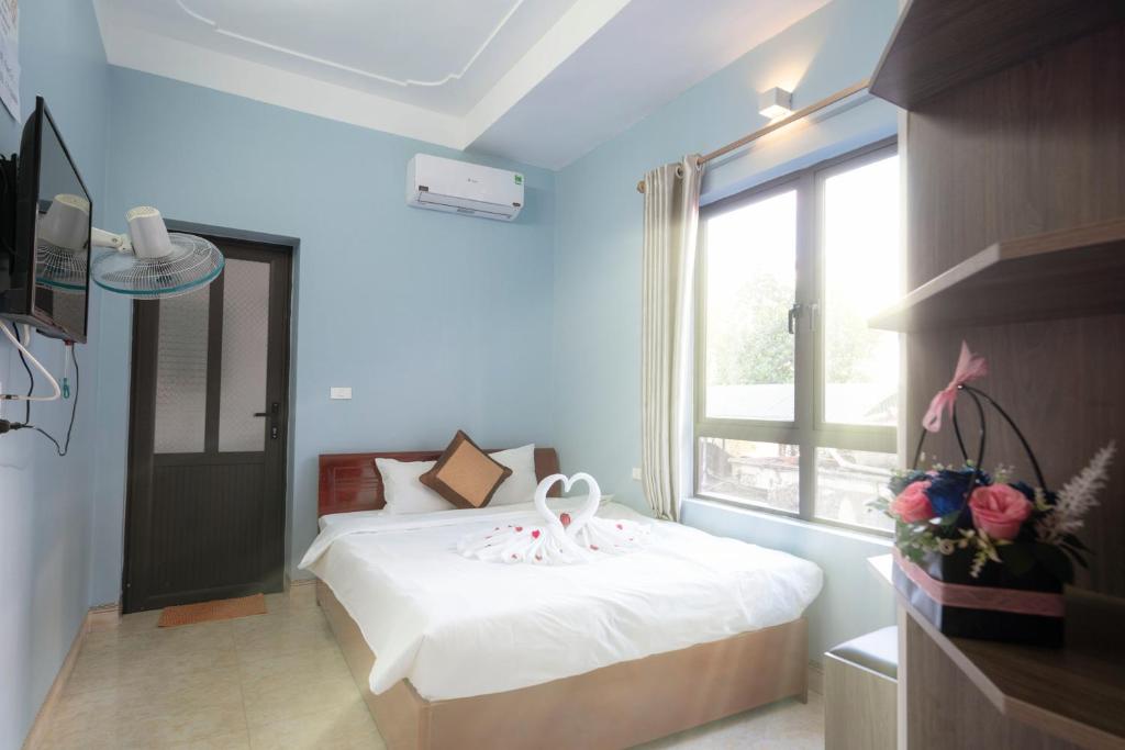 a bedroom with a white bed and a window at Fancy Hostel and Bar in Ha Long