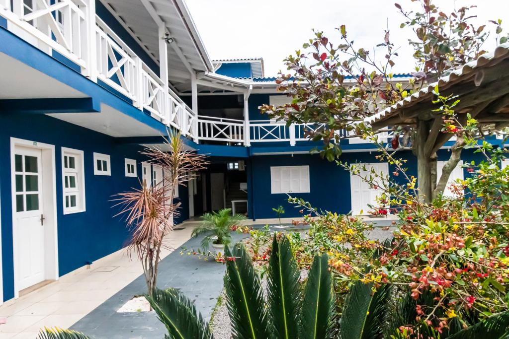 a blue building with plants in front of it at Pousada Lagoa dos Ventos in Barra de Ibiraquera