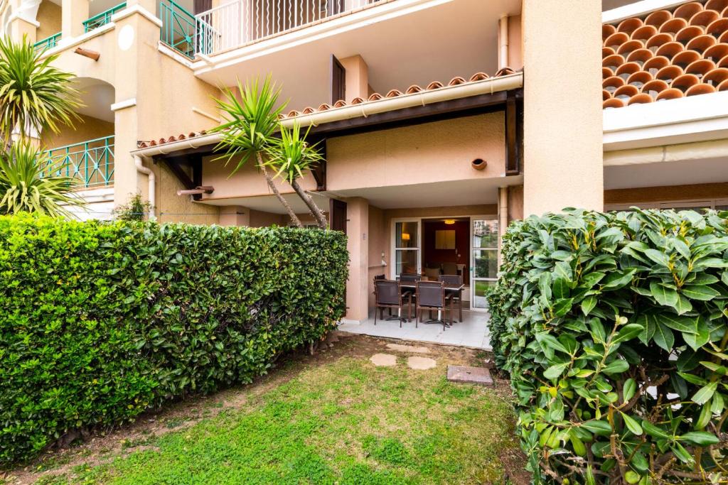 une maison avec une haie devant elle dans l'établissement Résidence le Village de Cap Esterel - maeva Home - Appartement 2 pièces 4 personnes - Confort MAE-6794, à Saint-Raphaël