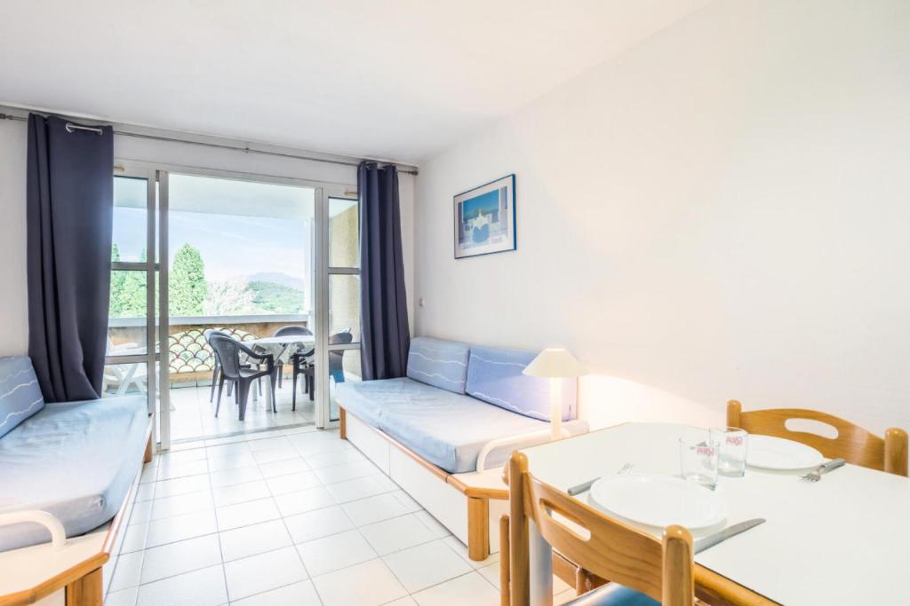 d'un salon avec un canapé et une table ainsi que d'un balcon. dans l'établissement Résidence le Village de Cap Esterel - maeva Home - Studio 5 personnes - Budget MAE-5883, à Saint-Raphaël