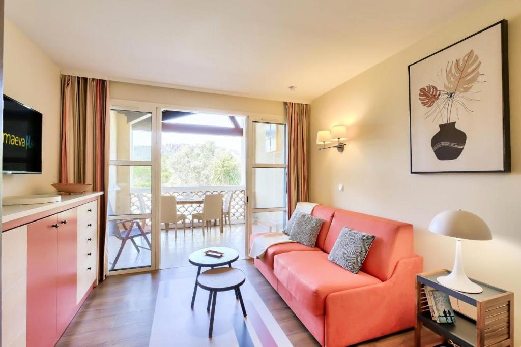 un salon avec un canapé orange et un balcon dans l'établissement Résidence le Village de Cap Esterel - maeva Home - Appartement 2 Pièces 4 Personnes - Sélection MAE-3114, à Saint-Raphaël